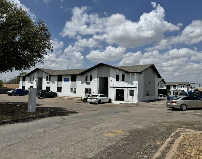 a building with cars parked in front of it at The  Landing Apartments