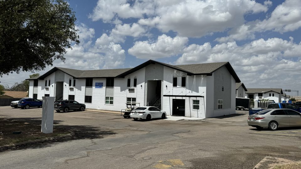 a building with cars parked in front of it at The  Landing Apartments