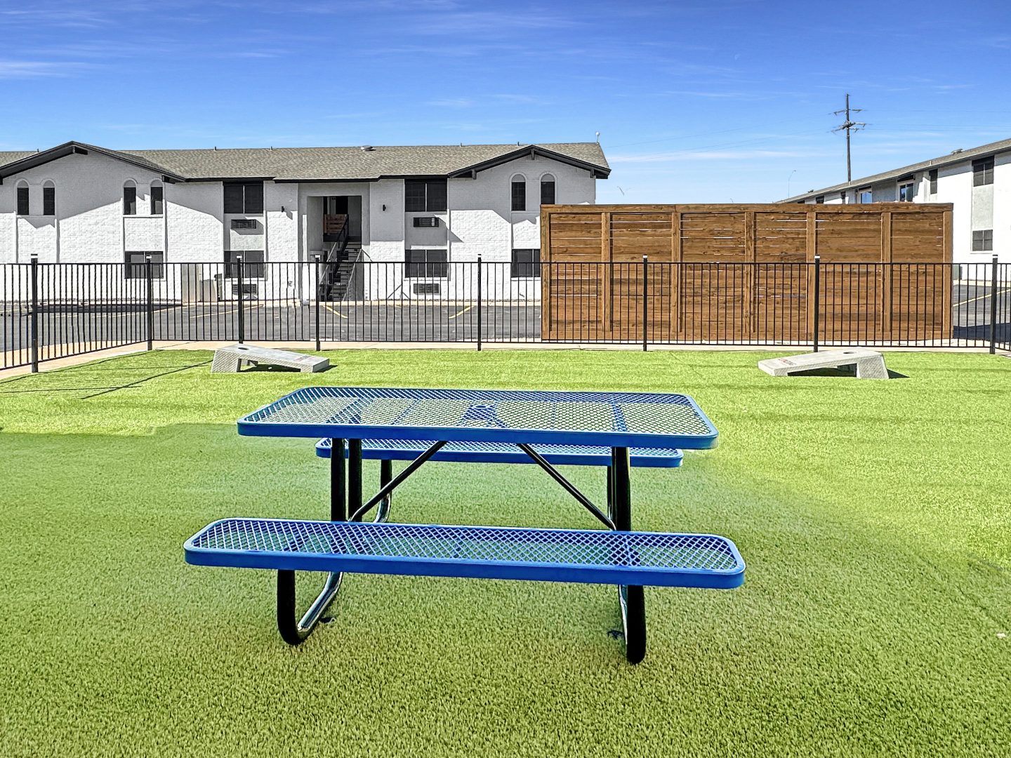 a blue picnic table in front of a grassy field at The  Landing Apartments