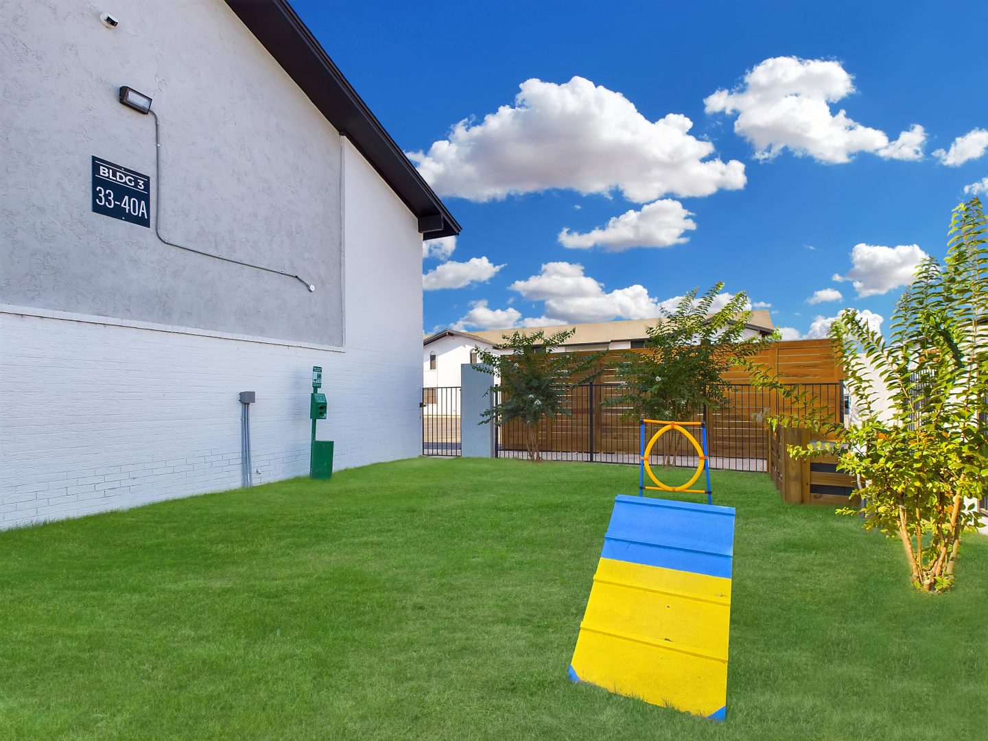 a backyard with a blue and yellow dog house at The  Landing Apartments